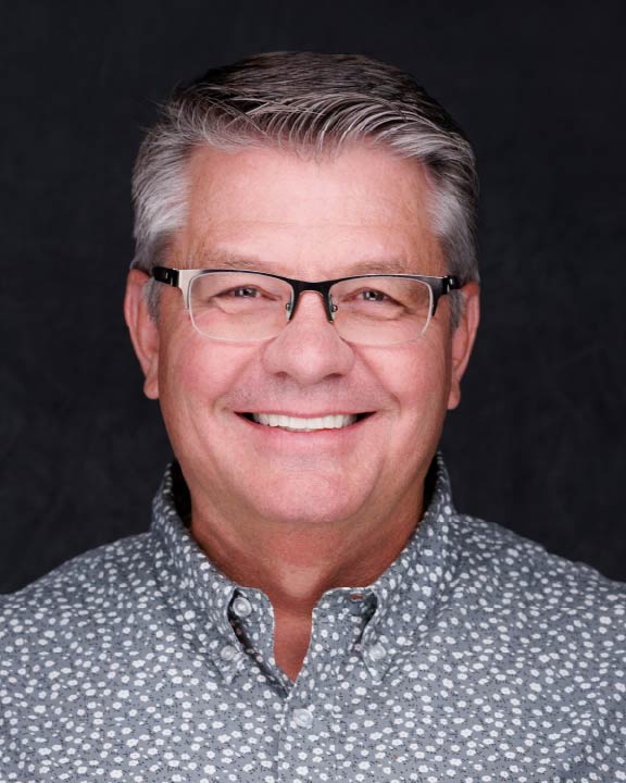 a man wearing glasses and a floral shirt