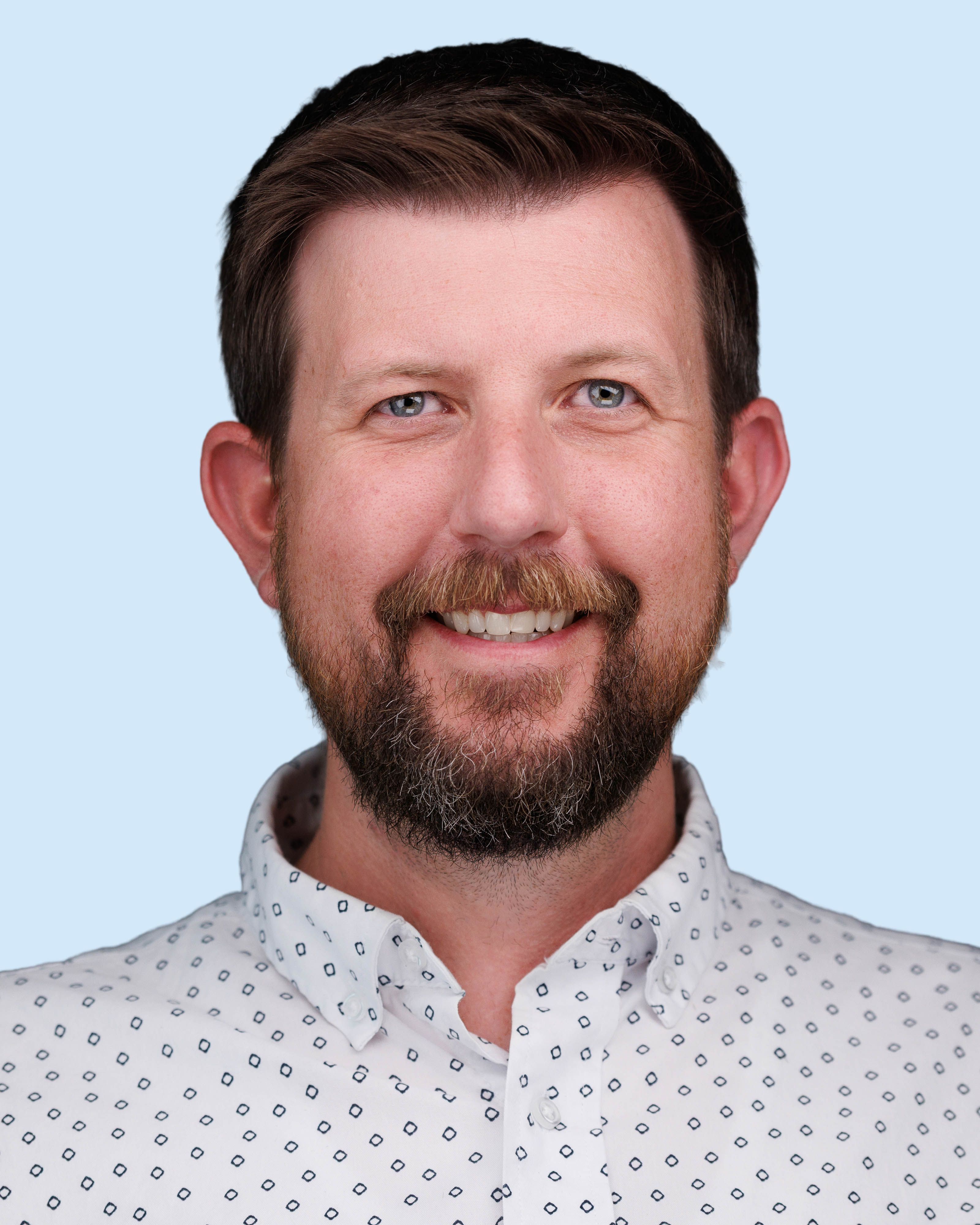 a man with a beard and mustache smiling