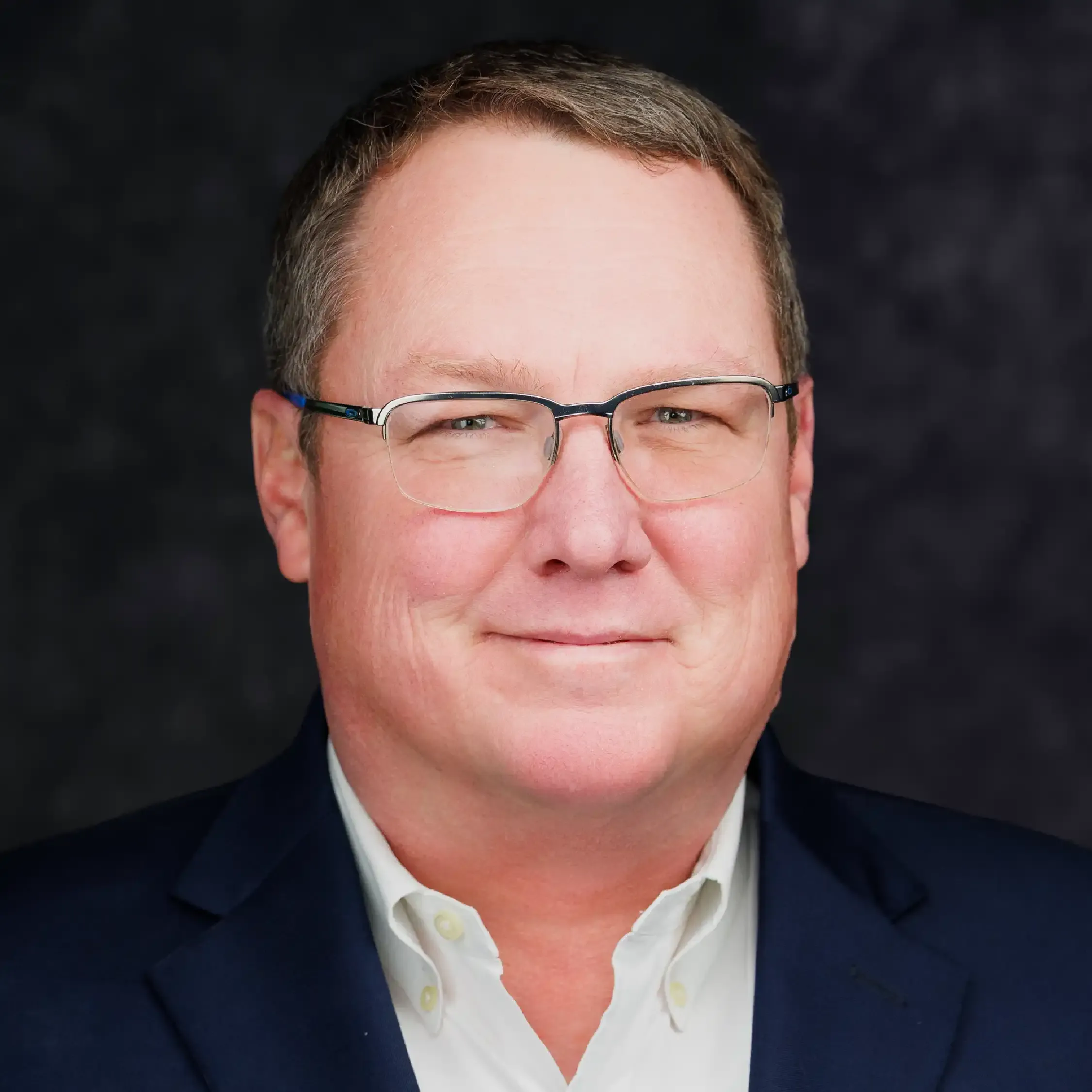 a man wearing glasses and a suit