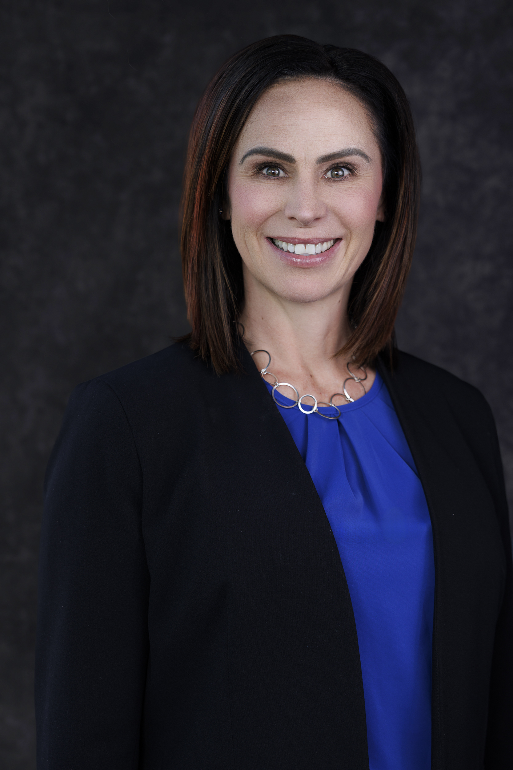 a woman in a blue shirt and black jacket